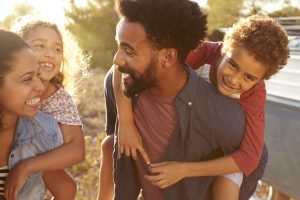 Parents giving their kids piggybacks, waist up, close up